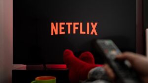 Persona utilizando una plataforma de streaming para escoger una serie o película en un televisor.