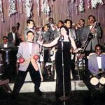 Gran orquesta tropical latinoamericana interpretando música en vivo durante la época dorada de las fiestas populares, símbolo del legado musical de agrupaciones como Billo's Caracas Boys, Los Melódicos y la Sonora Matancera.