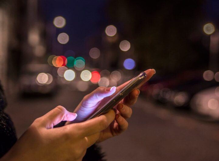 Persona utilizando un teléfono inteligente mientras está sola
